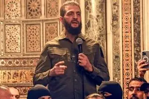 محمد الجولانی زیر کت و شلوارش سلاح پنهان می‌کند + ببینید 